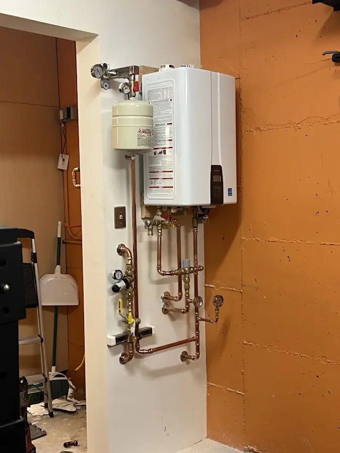 Plumbing technician inspecting water heater connections in Mount Vernon